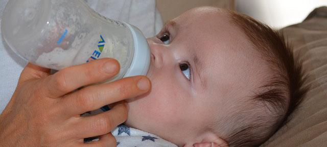 Infant child feeding from a bottle