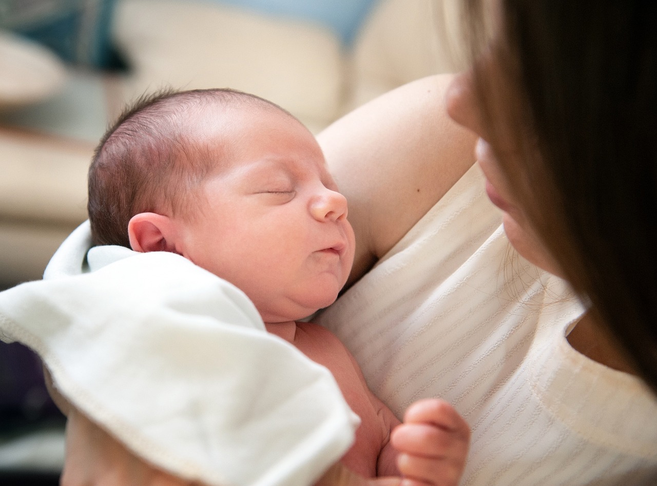 Sleeping baby held in mothers arms