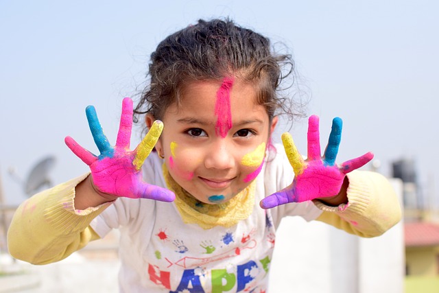 Little girl smiling and covered in paint