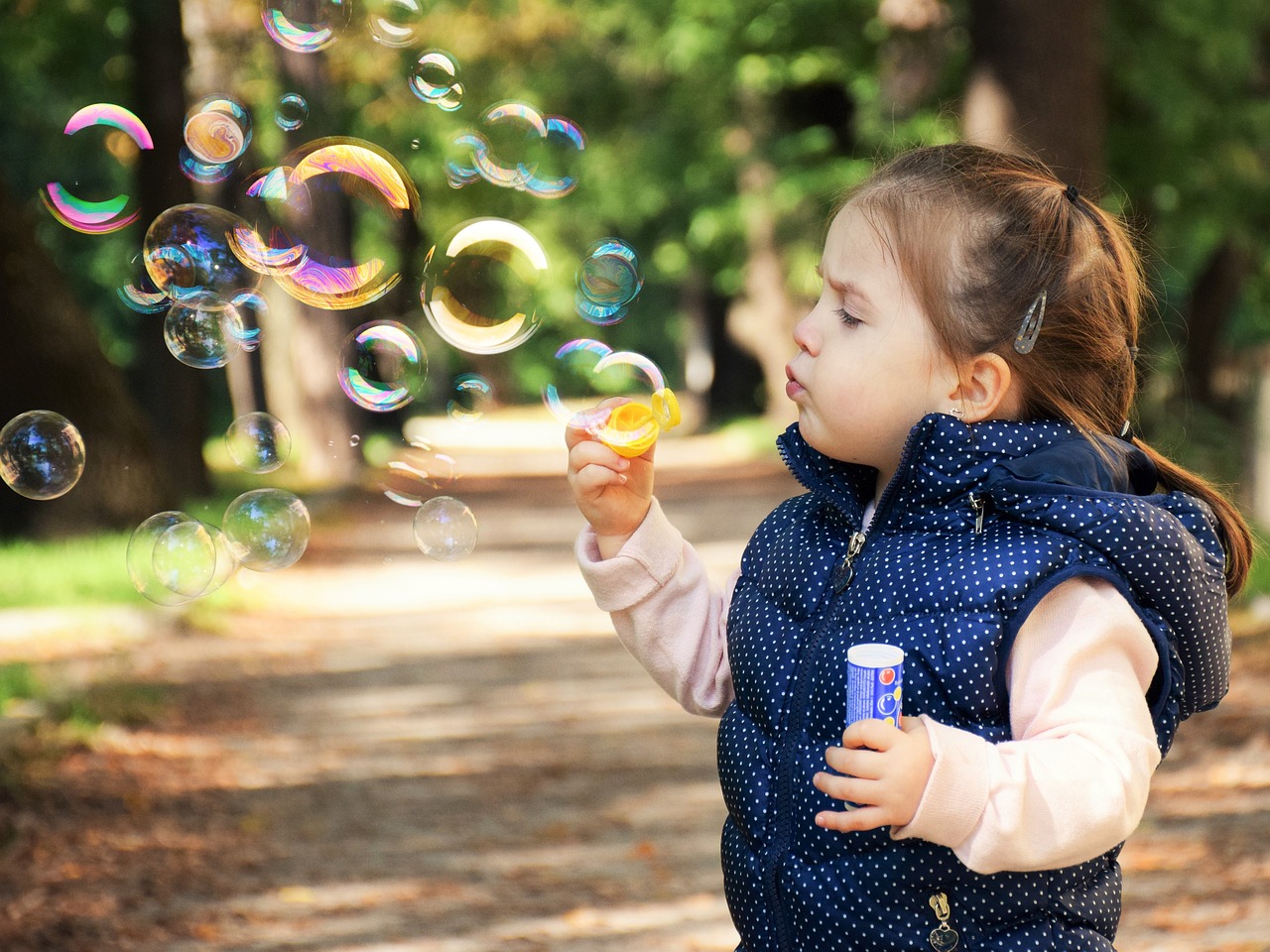 Toddler blowing bubbles outdoors